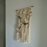 Modern macrame wall hanging with architectural fiber design and negative space