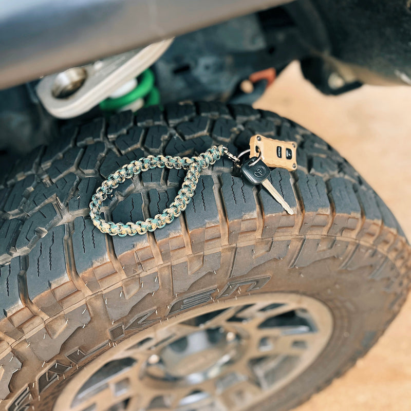 camo keychain resting on off-road truck tire