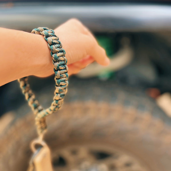 paracord camo keychain on wrist in front of truck
