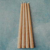 Set of four 10 inch hand-poured honey beeswax taper candles on neutral background