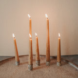 Set of 6 inch and 10 inch hand-poured honey beeswax taper candles burning, showing warm glow