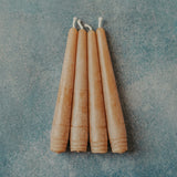 Set of four 6 inch hand-poured honey beeswax taper candles on neutral background