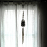 silhouette of plant hanger hanging from a curtain rod using the iron s hook