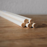 5 round wooden dowels displayed stacked on each other