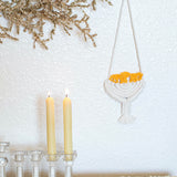 unique hanukkah decorations displayed in white on wall near lit candles and gold glittered foliage